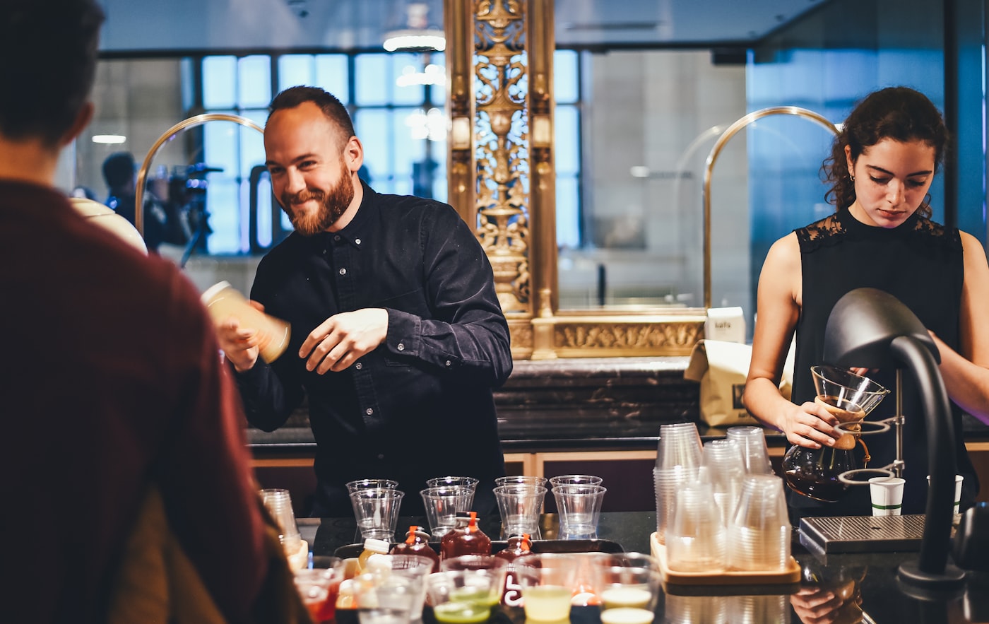Polished bartenders serving guests from a refined bar.