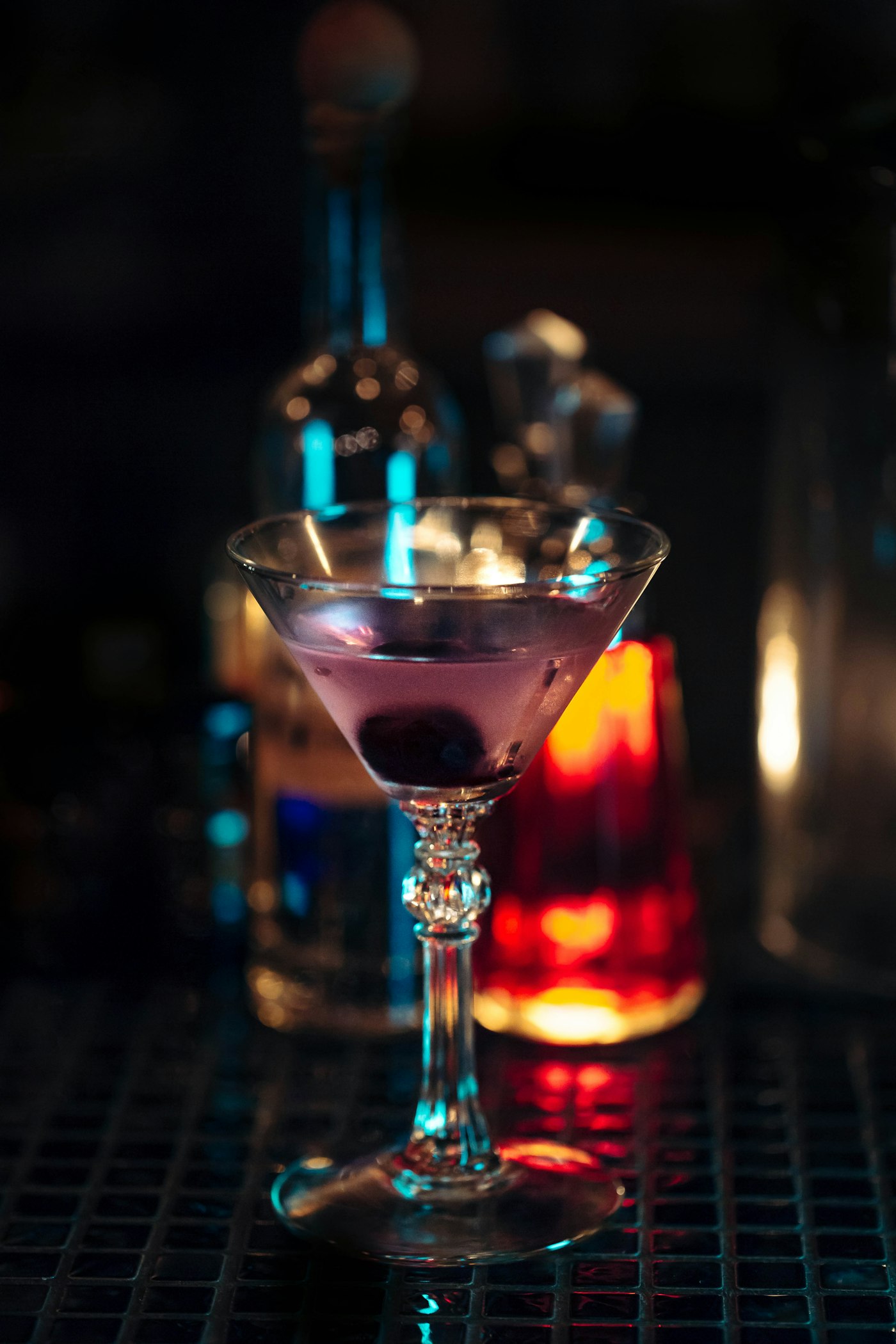 Moody cocktail glass on a luxury bar surface.