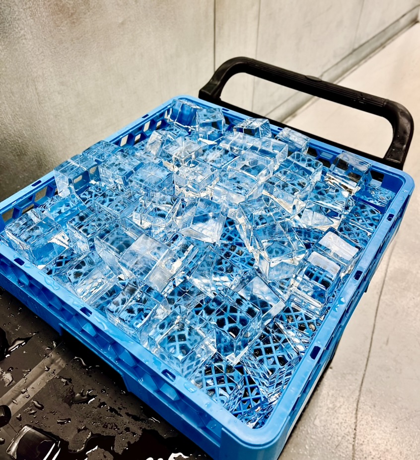 Blue crate filled with precision-cut clear ice ready for event service