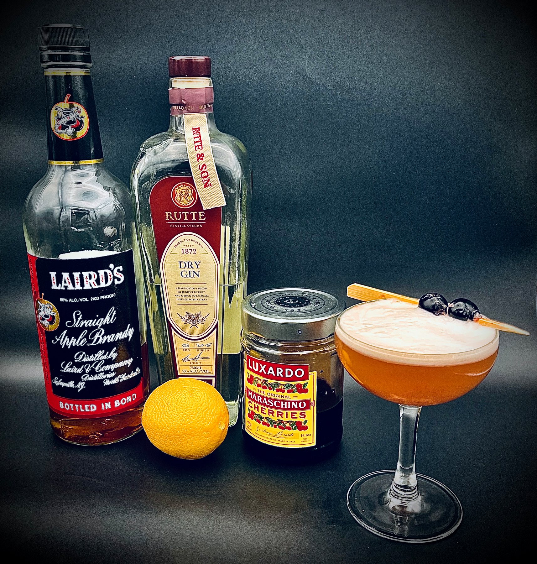 Cocktail ingredients arranged with a finished coupe drink
