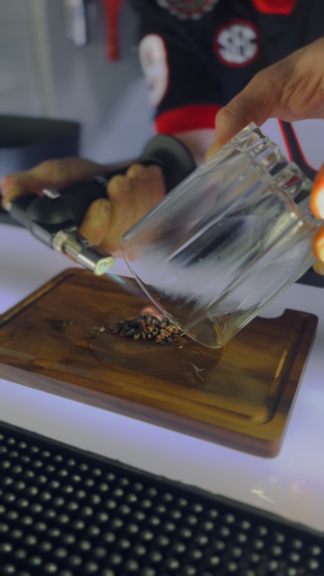 Smoked cocktail aromatics on a bar board